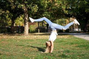 meisje praticing handstand in een park foto