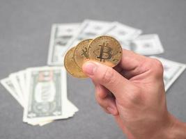 hand- Holding gouden bitcoin met de geld achtergrond digitaal geld concept foto