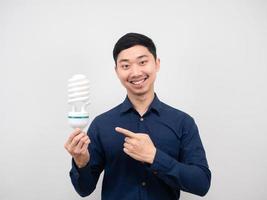 Mens glimlach en punt vinger Bij licht lamp in hand- wit achtergrond foto