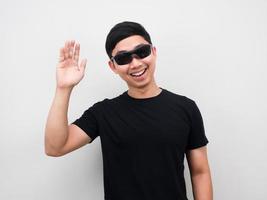 Mens vervelend zonnebril glimlachen en beweging hand- wit achtergrond foto