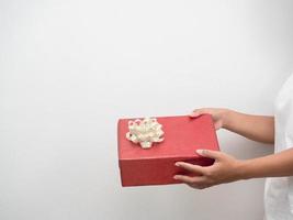 vrouw hand- Holding rood geschenk doos Aan wit achtergrond kopiëren ruimte foto
