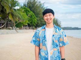 portret Aziatisch Mens toerisme kruis arm gelukkig glimlachen Aan de strand met mooi oceaan achtergrond kopiëren ruimte foto