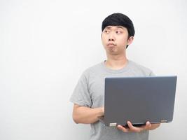 Aziatisch Mens gebruik makend van laptop en gevoel verveeld op zoek Bij kopiëren ruimte foto