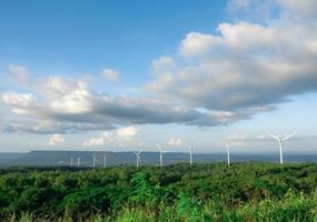 veel wind turbine Aan de berg met Woud en vallei achtergrond met de blauw lucht en bewolkt landschap uitzicht, wind generator Aan hoog grond in Woud foto