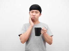 Mens grijs overhemd Holding koffie kop gebaar kiespijn ongezondheid concept foto