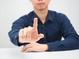 zakenman zittend Bij de bureau tonen vinger Duwen knop wit achtergrond foto