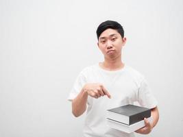 Aziatisch Mens punt vinger Bij boeken in hand- met verveeld gezicht kijken Bij camera Aan wit geïsoleerd achtergrond foto