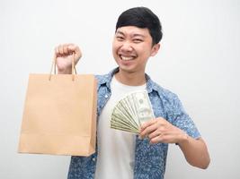 Aziatisch Mens geluk met winkelen, vrolijk Mens Holding een veel van geld en boodschappen doen zak foto