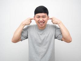 Mens gebaar plug vinger dichtbij zijn oor wit achtergrond foto