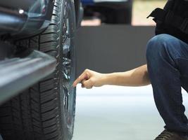 Mens hand- punt vinger Bij wiel van nieuw auto foto