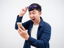 Aziatisch Mens Actie bril omhoog gevoel geschokt met mobiel telefoon in zijn hand- wit achtergrond foto
