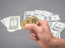 detailopname hand- Holding goud bitcoin en geld achtergrond foto