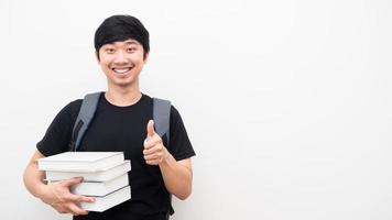 vrolijk Mens met school- rugzak en Holding boeken duim omhoog gelukkig glimlach gezicht wit achtergrond kopiëren ruimte foto