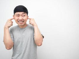 Aziatisch Mens gebaar plug vinger dichtbij zijn oor en op zoek Bij kopiëren ruimte wit achtergrond foto