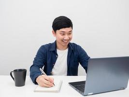 Mens werken Aan de bureau met laptop glimlachen wit achtergrond foto