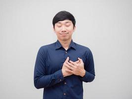 Aziatisch Mens tintje zijn hart door hand- met gelukkig gezicht dichtbij oog van zichzelf houden concept wit achtergrond foto