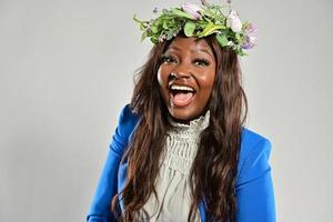 portret van een jong Afrikaanse Amerikaans vrouw , model- van mode, met groot bloemen in haar haar- foto