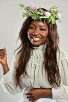 portret van een jong Afrikaanse Amerikaans vrouw , model- van mode, met groot bloemen in haar haar- foto