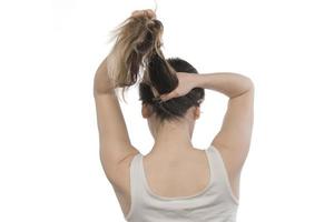 vrouw model- regelen van haar haar. vrouw koppelverkoop haar- in een broodje. foto