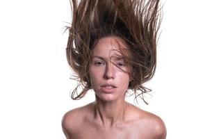 portret van een mooi vrouw met een lang haar. jong brunette model- met mooi haar- - geïsoleerd Aan wit achtergrond. jong meisje met haar- vliegend in de wind. foto