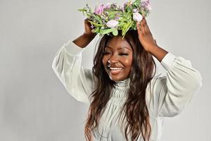 portret van een jong Afrikaanse Amerikaans vrouw , model- van mode, met groot bloemen in haar haar- foto