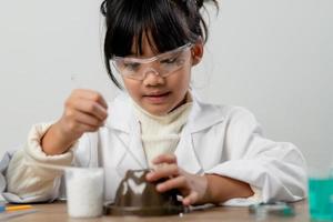 opleiding, wetenschap, chemie en kinderen concept - kinderen of studenten met test buis maken experiment Bij school- laboratorium foto