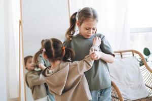 weinig meisjes zussen hebben strijd in de buurt spiegel in kinderen kamer Bij de huis foto