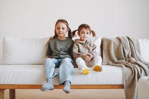 genezen twee kinderen meisjes zussen hebben pret Aan bankstel Bij huis foto