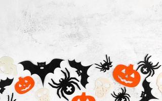 minimalistisch halloween achtergrond met schedels, pompoenen, vleermuizen abd spinnen Aan wit beton achtergrond. uitnodiging of kaart voor oktober 31.kopie ruimte foto