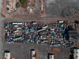 stapel van kleurrijk weggegooid auto's Aan autokerkhof in een woestijn foto