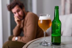 depressief verdrietig jong verslaafd Mens gevoel slecht drinken bier alleen Bij huis, benadrukt gefrustreerd eenzaam drinker alcoholisch lijden van alcohol verslaving hebben probleem, alcoholisme concept foto