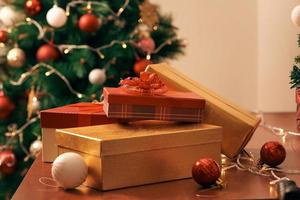 versierd Kerstmis boom met kleurrijk ballen en geschenk dozen Bij huis foto