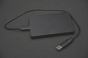 een zwart portable moeilijk rit Aan een zwart achtergrond. informatie opslag. persoonlijk apparaatje. foto