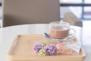 gecondenseerd melk thee of koffie met koekje en bloem rekwisieten geserveerd foto