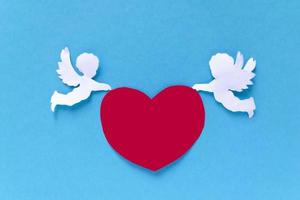 valentijnsdag dag begrip. rood harten en Cupido Aan blauw achtergrond. creatief Valentijnsdag dag kaart. foto
