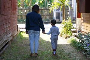 een moeder wandelingen door de hand- van haar zoon naar wandelen buiten de huis. zacht en selectief focus. foto