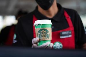 Starbucks arbeiders geven bestellingen Bij de doorrijden. heet koffie Aan exclusief Kerstmis verpakking beker. saudi Arabië, khobar, 18 december 2022. foto