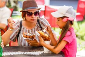 moeder en kinderen aan het eten bubbel wafel met ijs room foto