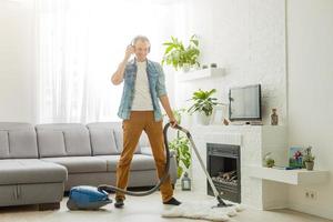 coronavirus pandemie. een Mens met een vacuüm schoonmaakster in zijn appartement. huis kantoor. quarantaine. afgelegen werk. een Mens in een bedrijf overhemd en onderbroek houdt. foto