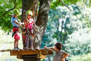 avontuur beklimming hoog draad park - kinderen Aan Cursus touw park in berg helm en veiligheid uitrusting foto