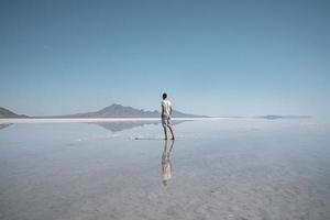 Mens bezienswaardigheden bekijken bonneville zout vlak en bergen gedurende zomer vakantie foto