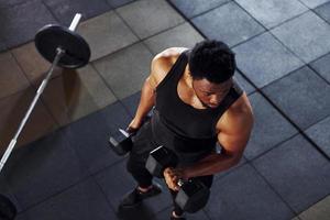 sterk Afrikaanse Amerikaans Mens in sportief kleren hebben training dag in de Sportschool foto