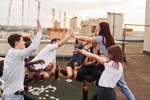 eenheid van mensen. groep van jong mensen in gewoontjes kleren hebben een partij Bij op het dak samen Bij dag foto