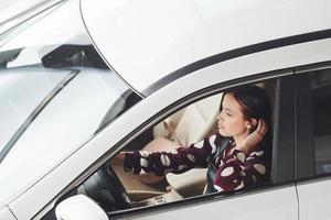 kant visie van mooi jong brunette dat binnen van modern auto. rijden auto foto