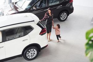 moeder met haar dochter wandelen samen in de buurt modern auto- binnenshuis foto