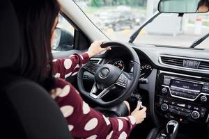 dichtbij omhoog visie van mooi jong brunette dat binnen van modern auto. rijden auto foto