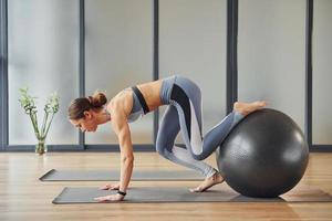 toepassingen geschiktheid bal. jong vrouw in sportief slijtage en met slank lichaam hebben yoga dag binnenshuis foto