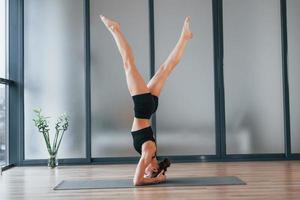 moeilijk oefening. jong vrouw in sportief slijtage en met slank lichaam hebben geschiktheid yoga dag binnenshuis foto