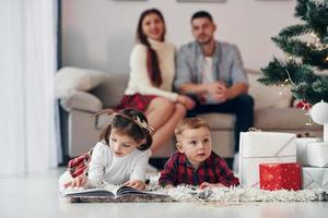 zus en broer hebben plezier. mooi familie viert nieuw jaar en Kerstmis binnenshuis Bij huis foto