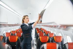 leeg stoelen. jong stewardess Aan de werk in de passagier vliegtuig foto